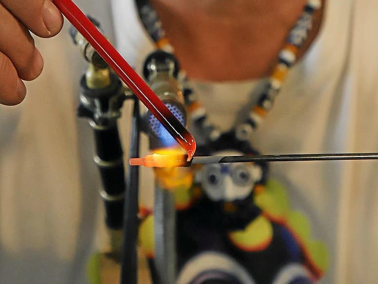 Manolo Muñoz Cuenca trabajando con varilla de vidrio y mandril al fuego del candilón